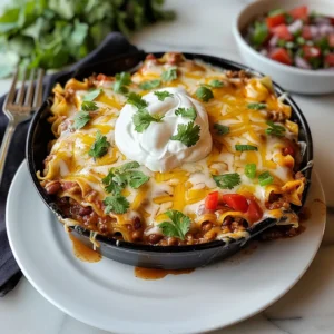 A delicious-looking taco lasagna in a cast iron skillet, topped with melted cheese and fresh cilantro.