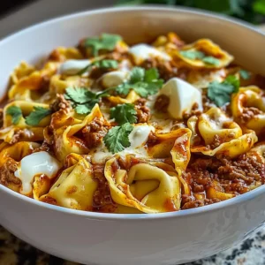Cheesy beef enchilada tortellini in a white bowl, topped with melted cheese and parsley.