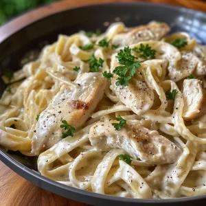 A vibrant plate of Chicken Fettuccine Alfredo with golden chicken pieces and rich creamy pasta.