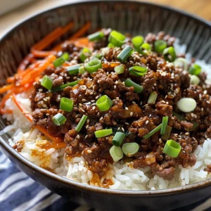A vibrant Korean Ground Beef Bowl featuring ground beef, a fried egg, and assorted vegetables on a bed of rice.