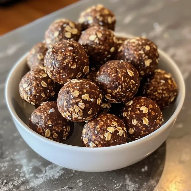 Juicy no-bake brownie balls displayed with a shiny chocolate coating and puffed rice on top.
