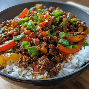 Juicy beef and pepper rice bowl topped with diced green onions and avocado.