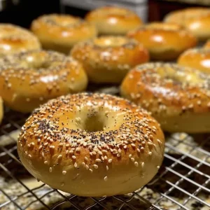 Juicy homemade everything bagels displayed on a rustic wooden surface.