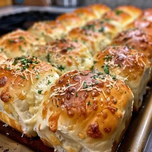 Side view of golden-brown Garlic Butter Parmesan Rolls with garlic cloves.