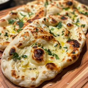 Juicy Cheese Garlic Naan highlighted with a glossy buttered surface and herbs.