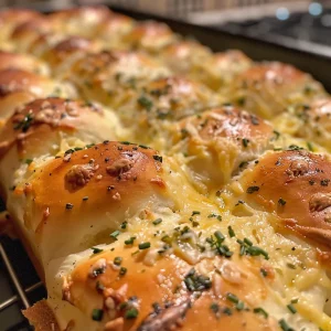 Juicy cheesy garlic rolls with a crispy exterior and gooey cheese inside, captured in detail.