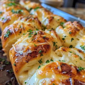 Juicy garlic rolls stacked, revealing melted mozzarella and rich garlic butter.