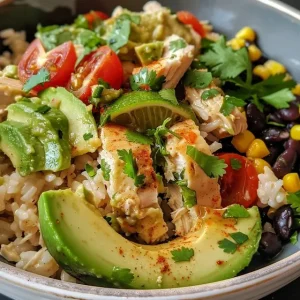 Close-up view of a creamy avocado chicken rice bowl with vibrant ingredients.