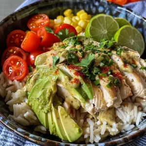 A close-up view of a creamy avocado chicken rice bowl with vibrant colors.