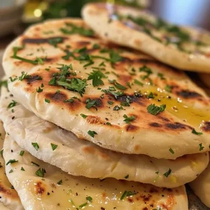 Juicy, delicious Greek pita bread displayed on a wooden surface.