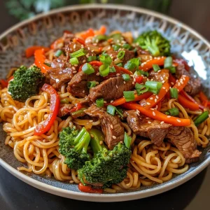 Close-up view of a beef stir-fry with noodles, featuring colorful vegetables and a glossy sauce.