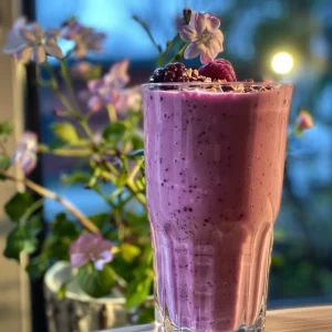 Side view of a creamy Berry Vanilla Protein Smoothie in a glass.