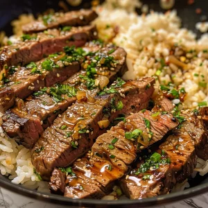 A close-up side view of Honey Garlic Butter Steak and Rice Skillet, showcasing juicy steak strips and fluffy rice.