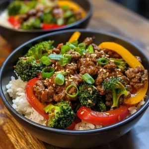 ['Close-up view of a meal prep bowl filled with teriyaki beef, colorful vegetables, and garnished with green onions.', 'Side angle of a delicious teriyaki beef meal prep bowl showcasing ground beef, broccoli, and bell peppers.', 'Juicy teriyaki beef meal prep bowl featuring vibrant vegetables, arranged neatly in a container.', 'Detailed side view of teriyaki beef mixed with vegetables inside a meal prep bowl, highlighting the fresh ingredients.']