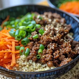 ['Juicy Korean beef and quinoa bowl topped with sliced green onions.', 'Close-up of a vibrant quinoa bowl with ground beef and garlic.', 'Side view of a delicious Korean beef dish with colorful ingredients.', 'Mouth-watering Korean beef served over fluffy quinoa with herbs.']