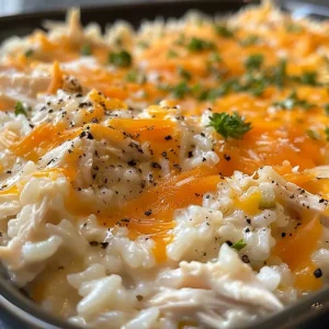['Close-up view of juicy Ranch Chicken and Rice on a plate.', 'Side view of a colorful dish featuring chicken, rice, and vegetables.', 'Appetizing close-up of chicken breasts served with rice and peas.', 'Freshly cooked Ranch Chicken and Rice, highlighting creamy texture and vibrant colors.']