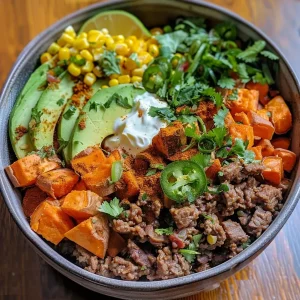 ['Close-up view of a colorful Street Corn Beef Bowl filled with sweet potatoes, ground beef, and toppings.', 'Side view of a juicy Street Corn Beef Bowl showcasing corn, avocado, and green onions.', 'Detailed image of a vibrant Street Corn Beef Bowl with ingredients like jalapeños and cilantro.', 'An appetizing Street Corn Beef Bowl featuring layers of beef, corn, and garnishes in a bowl.']