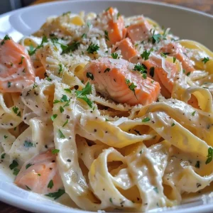 ['A close-up side view of creamy salmon pasta garnished with fresh herbs.', 'A juicy serving of fettuccine topped with salmon and creamy sauce.', 'Delicious creamy salmon pasta presented in a bowl with a sprinkle of herbs.', 'A plated dish of fettuccine with chunks of salmon and a rich cream sauce.']
