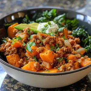 ['Close-up view of a ground turkey and sweet potato bowl with fresh spinach.', 'Side angle of a colorful ground turkey bowl featuring diced sweet potatoes and avocado.', 'Juicy ground turkey mixed with sweet potatoes and garnished with Greek yogurt.', 'Ground turkey and sweet potato bowl served in a rustic dish, showcasing fresh ingredients.']