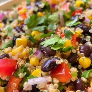 ['A close-up side view of a colorful Quinoa and Black Bean Salad in a bowl.', 'Vibrant Quinoa and Black Bean Salad showcasing fresh ingredients and lime dressing.', 'A detailed close-up of a Quinoa and Black Bean Salad filled with colorful vegetables.', 'A side view of a fresh Quinoa and Black Bean Salad served in a bowl with lime dressing.']