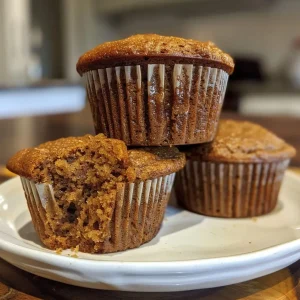 ['Close-up side view of freshly baked gingerbread muffins, showcasing their textured top.', 'Side profile of golden-brown gingerbread muffins arranged neatly on a plate.', 'Juicy gingerbread muffins with a moist appearance, highlighted in a side view.', 'A detailed look at gingerbread muffins, emphasizing their fluffy interior and spiced top.']