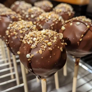 ['Close-up of colorful homemade cake pops on a white plate.', 'Side view of decorative cake pops topped with sprinkles.', 'Juicy homemade cake pops with a shiny glaze displayed on a table.', 'Assorted cake pops in vibrant colors, presented in a dessert stand.']